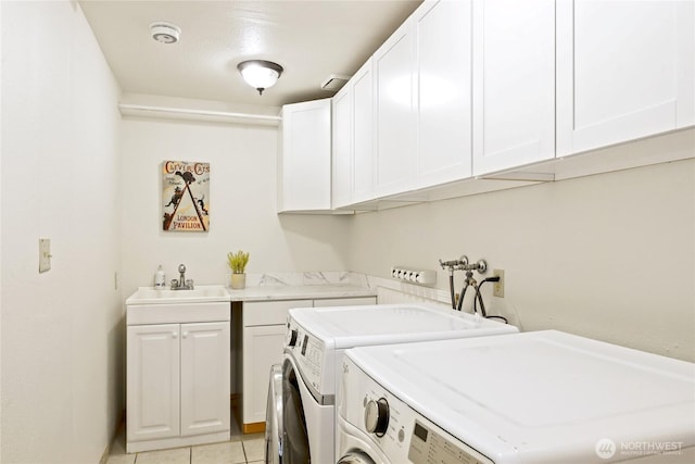 clothes washing area with light tile patterned floors, cabinet space, a sink, and separate washer and dryer