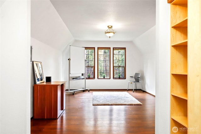 additional living space with vaulted ceiling, built in shelves, and dark wood-style flooring