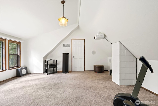 interior space featuring carpet flooring, vaulted ceiling, and baseboards