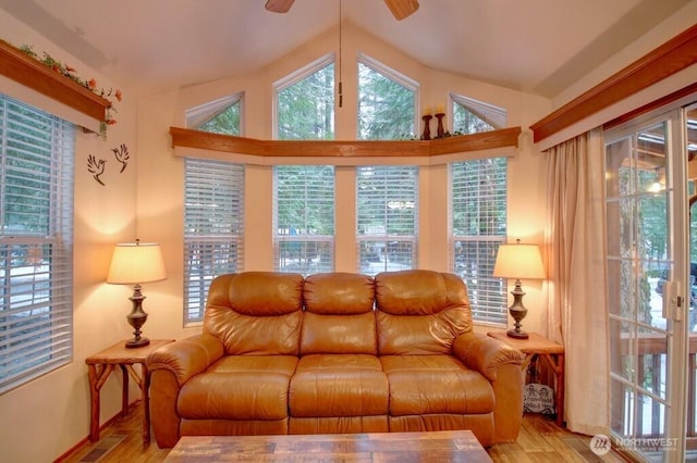 living room featuring a ceiling fan, lofted ceiling, visible vents, and wood finished floors