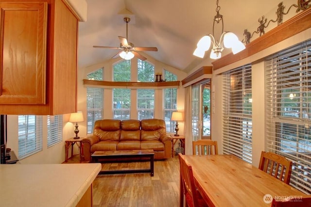 interior space with lofted ceiling, light wood finished floors, and ceiling fan with notable chandelier