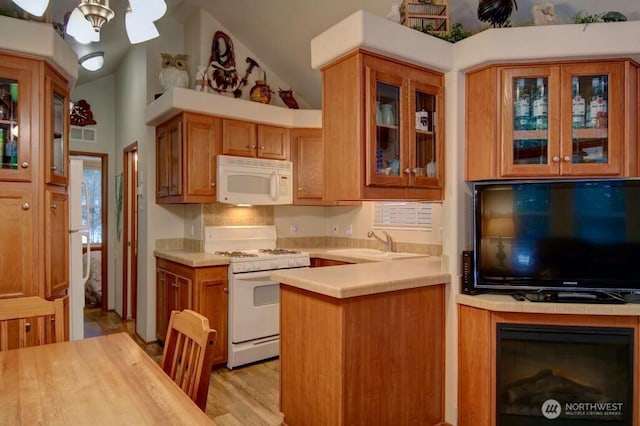 kitchen featuring tasteful backsplash, light countertops, brown cabinetry, a sink, and white appliances