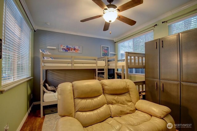 bedroom featuring ceiling fan, crown molding, baseboards, and wood finished floors