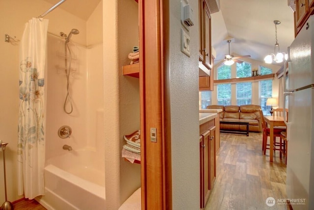 bathroom featuring shower / tub combo, vaulted ceiling, vanity, and wood finished floors