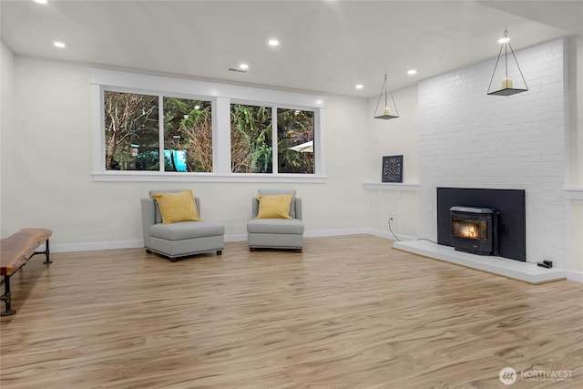 living area with light wood-style flooring, visible vents, baseboards, and recessed lighting