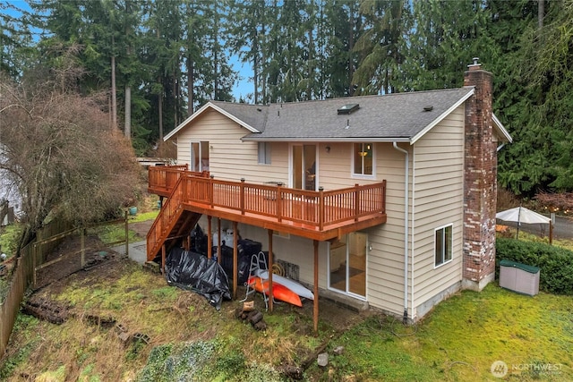 back of property with a deck, stairway, a chimney, and a shingled roof