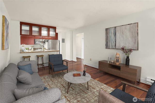 living area featuring dark wood-style flooring, baseboards, and baseboard heating