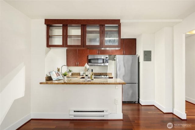 kitchen with a peninsula, dark wood-type flooring, a sink, appliances with stainless steel finishes, and baseboard heating