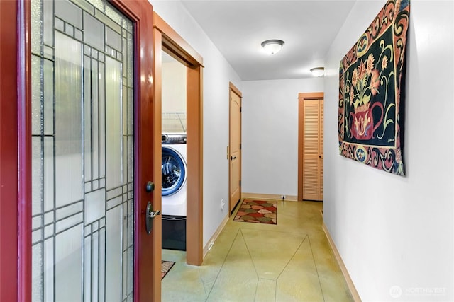 corridor with baseboards and washer / clothes dryer