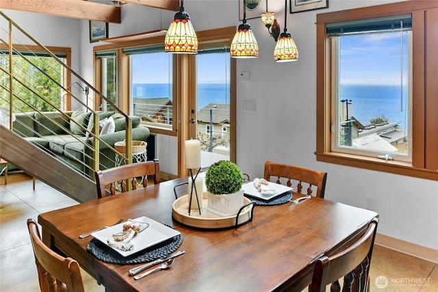 dining area with a water view and baseboards