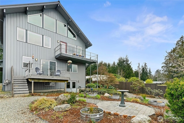 back of house featuring fence, a balcony, and a patio