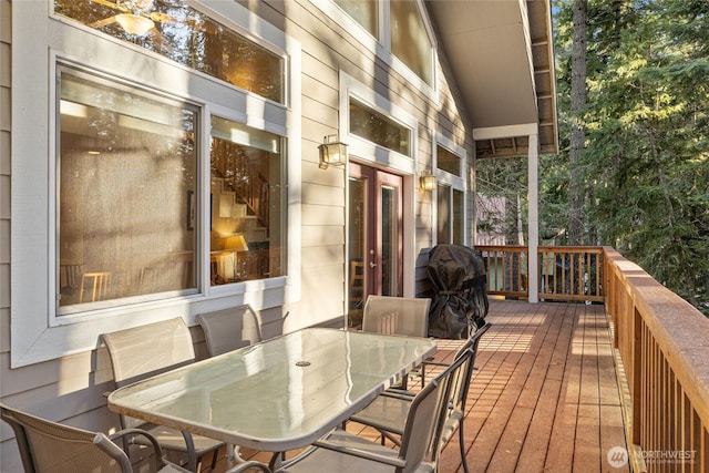 wooden terrace featuring outdoor dining space and grilling area