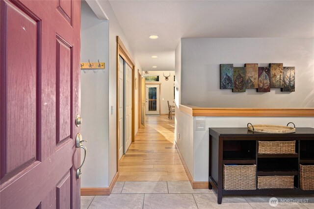 corridor featuring recessed lighting, light tile patterned flooring, and baseboards