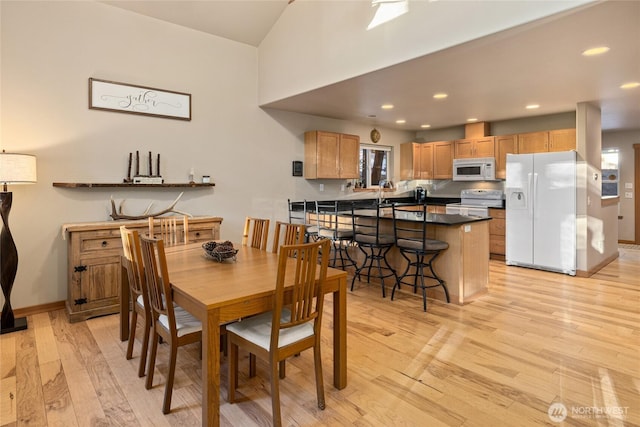 dining area with light wood-type flooring, baseboards, and recessed lighting