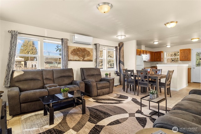 living room with an AC wall unit, light tile patterned flooring, and baseboards