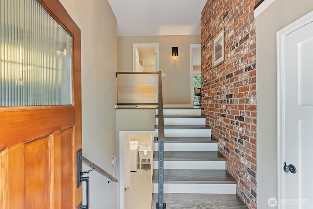 stairway featuring brick wall