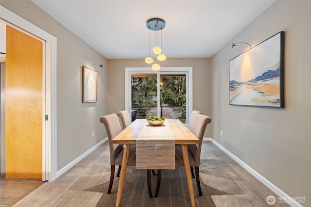 dining space with carpet and baseboards