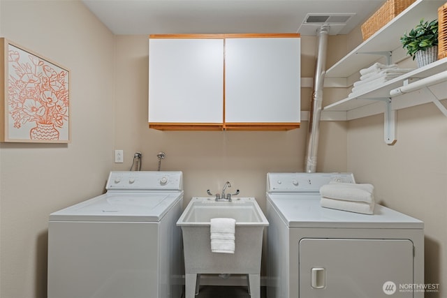 laundry area with cabinet space, visible vents, separate washer and dryer, and a sink