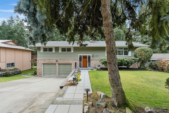 bi-level home with a garage, concrete driveway, brick siding, and a front lawn