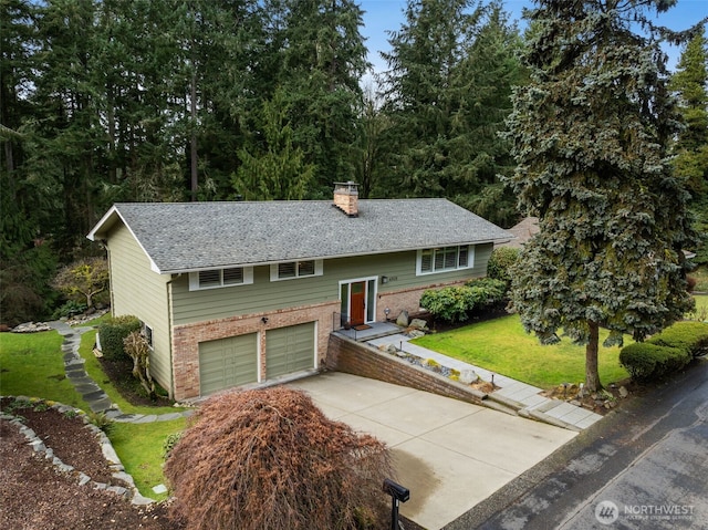 split foyer home with a garage, brick siding, driveway, a front lawn, and a chimney