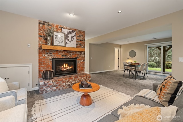 living room with a brick fireplace, carpet, and baseboards