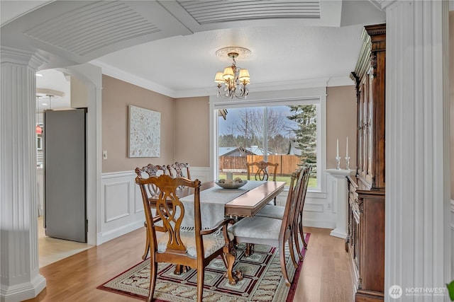 dining area featuring arched walkways, crown molding, a notable chandelier, visible vents, and light wood-style flooring