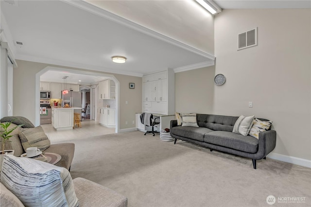 living room with arched walkways, crown molding, light colored carpet, visible vents, and baseboards