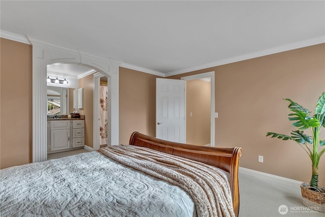 carpeted bedroom with arched walkways, crown molding, and baseboards