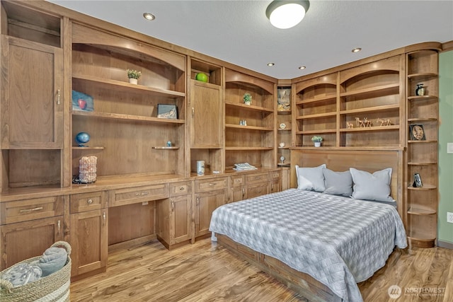 bedroom featuring recessed lighting, built in study area, and light wood-style floors