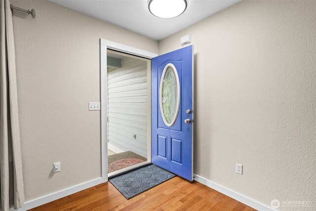 foyer with baseboards and wood finished floors