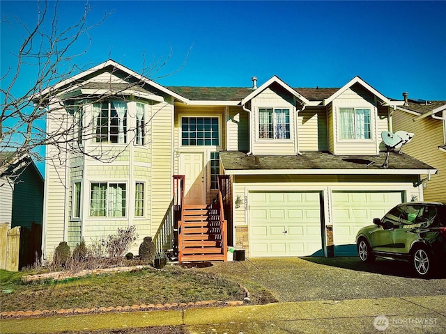 raised ranch with a garage and aphalt driveway