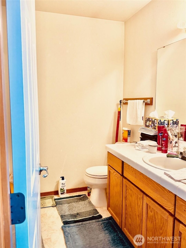 bathroom featuring tile patterned flooring, vanity, and toilet