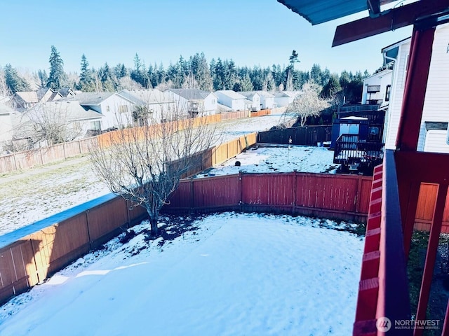 yard layered in snow featuring a residential view and a fenced backyard