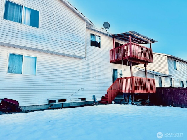 snow covered house featuring a balcony