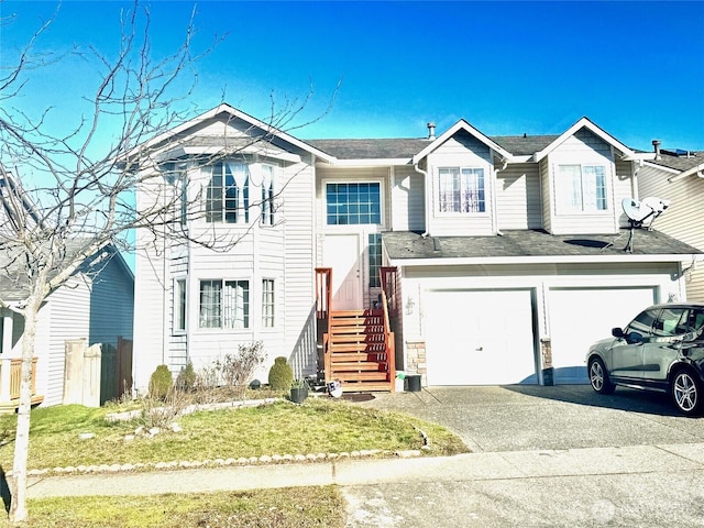 view of front of property featuring driveway, an attached garage, and fence