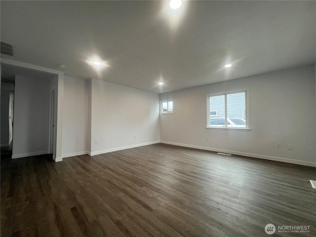 empty room featuring visible vents, baseboards, dark wood-type flooring, and recessed lighting