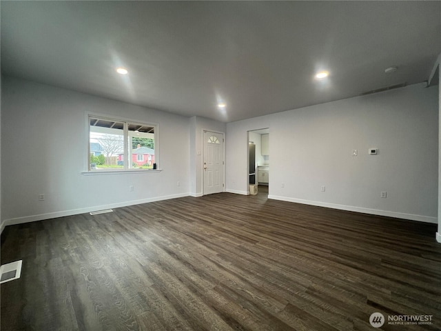 spare room with baseboards, visible vents, dark wood-type flooring, and recessed lighting