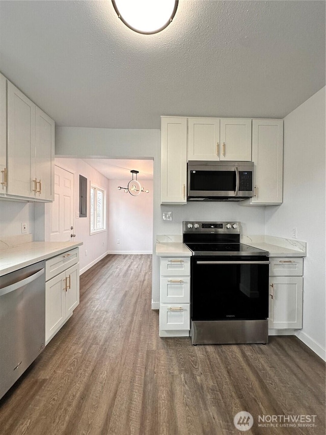 kitchen featuring appliances with stainless steel finishes, dark wood-style flooring, light countertops, and white cabinetry