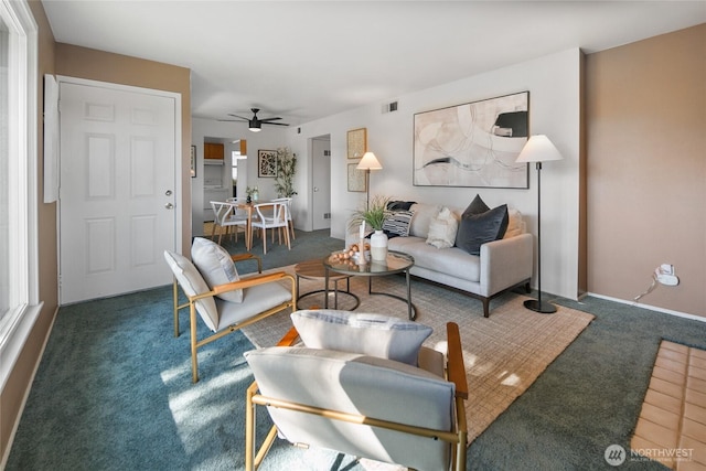 living area featuring a ceiling fan, visible vents, and carpet flooring