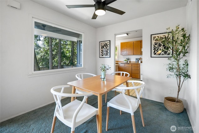 dining space with ceiling fan, baseboards, and dark colored carpet