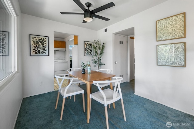 dining area with dark colored carpet, plenty of natural light, visible vents, and a ceiling fan