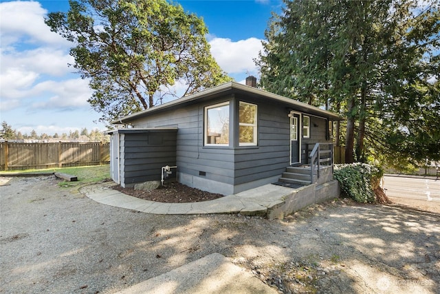 exterior space featuring crawl space, fence, and a chimney