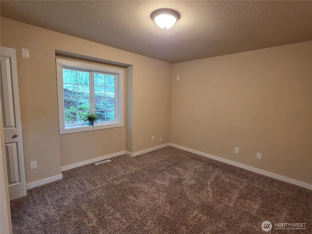 carpeted spare room featuring visible vents, a textured ceiling, and baseboards