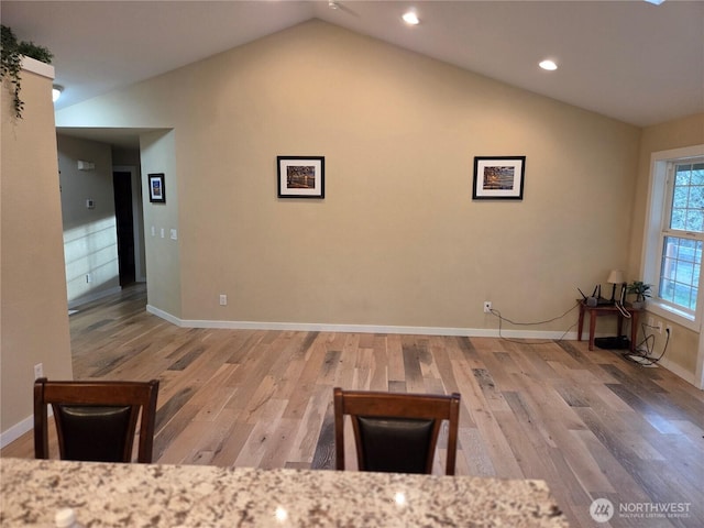 interior space with lofted ceiling, wood finished floors, and baseboards