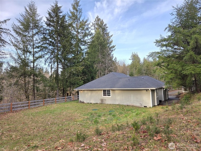 exterior space with fence and a lawn