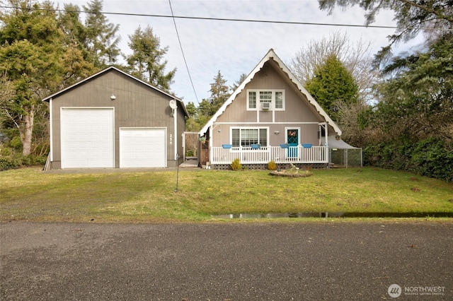 view of front of property featuring an outbuilding, a front lawn, a porch, and a detached garage