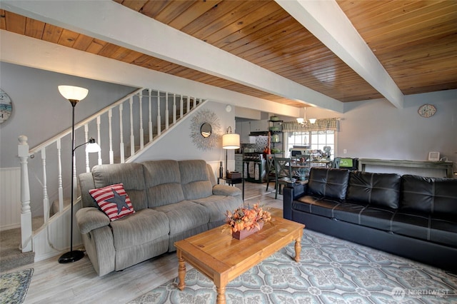 living area featuring stairway, wooden ceiling, wood finished floors, and beam ceiling