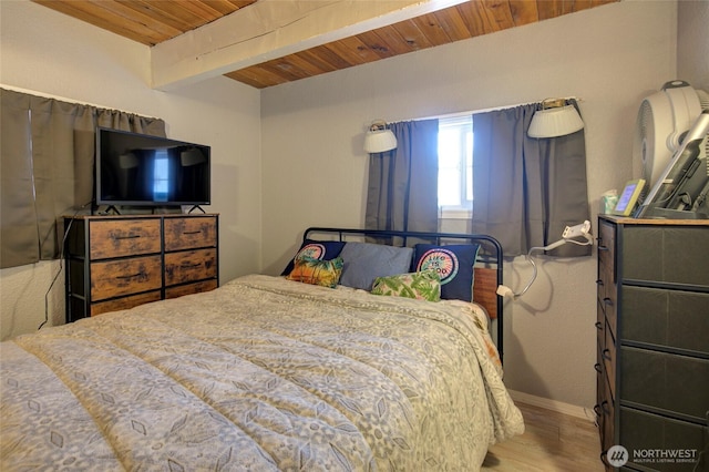 bedroom featuring wooden ceiling, beamed ceiling, baseboards, and wood finished floors