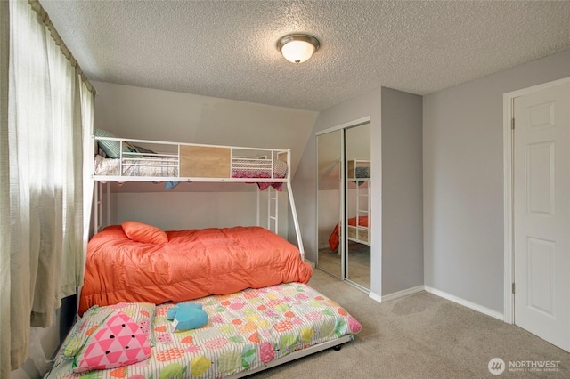 bedroom featuring carpet, a textured ceiling, baseboards, and a closet