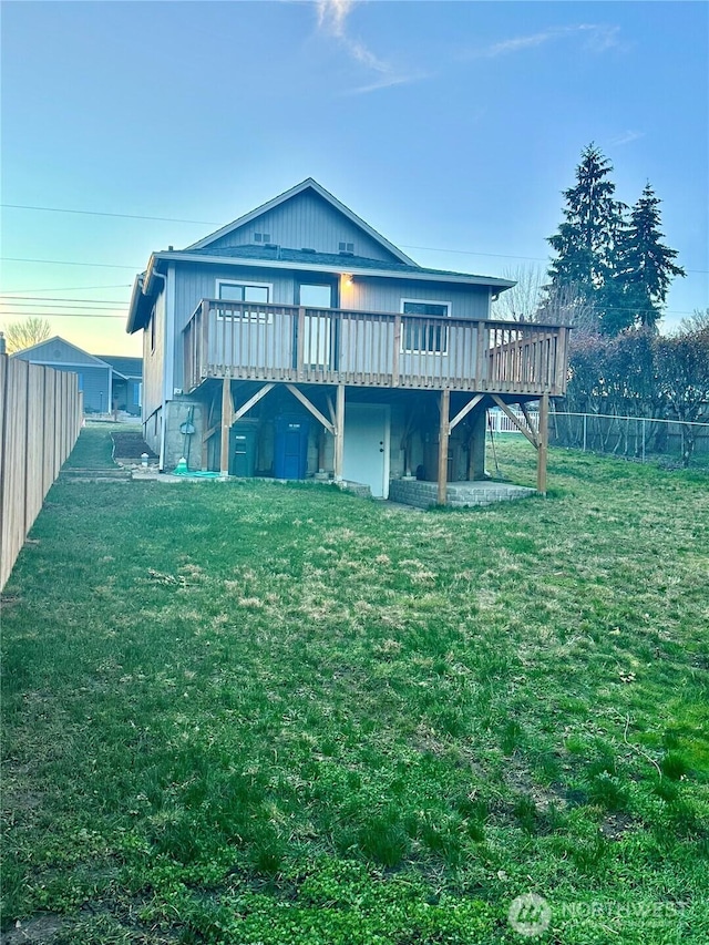 rear view of property with fence private yard, a yard, and a deck